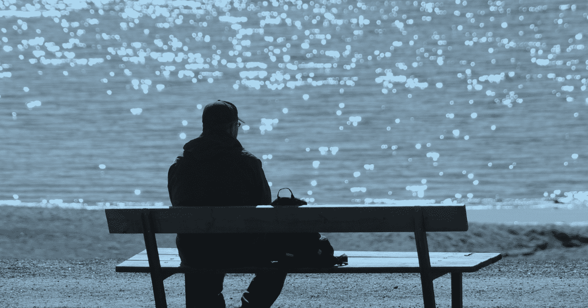 man sitting on a bench signifying tired of being alone and wants to find love
